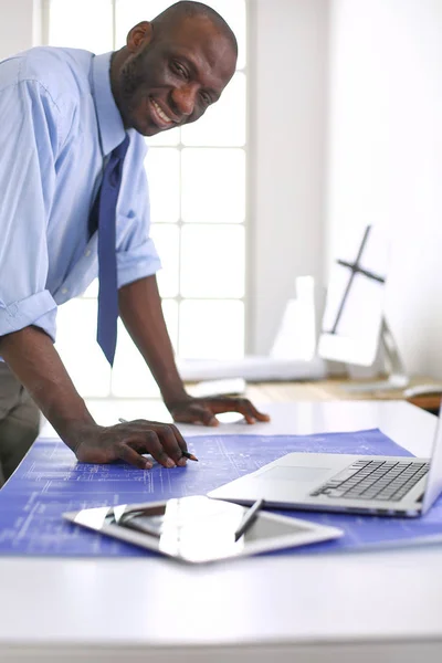 Architecte afro-américain travaillant avec l'ordinateur et les plans dans le bureau — Photo