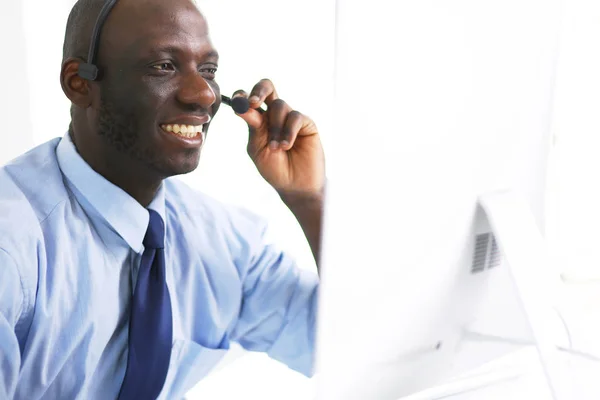 Homme d'affaires afro-américain sur casque de travail sur son ordinateur portable — Photo