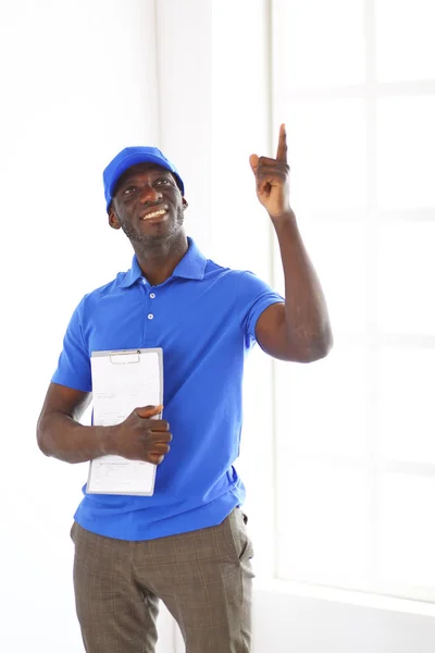 Retrato de un apuesto entregador feliz con carpeta —  Fotos de Stock