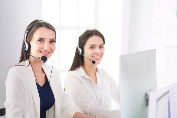 Empresária sorridente ou operador de linha de ajuda com fone de ouvido e computador no escritório — Fotografia de Stock