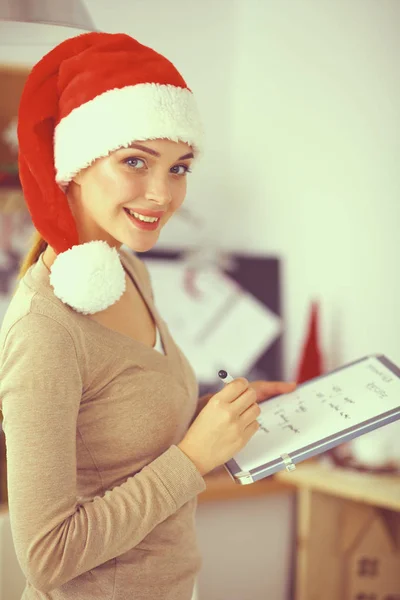 Lächelnde junge Frau in der Küche, isoliert auf weihnachtlichem Hintergrund. — Stockfoto
