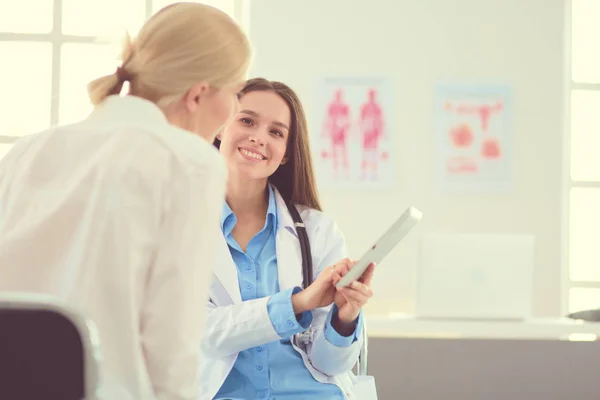 Dokter en patiënt bespreken iets terwijl ze aan tafel zitten. Begrip "geneeskunde en gezondheidszorg" — Stockfoto