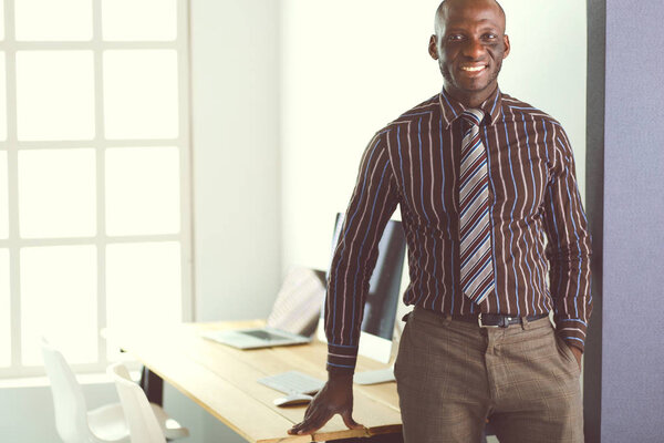 Portrait of an handsome black businessman standing in office
