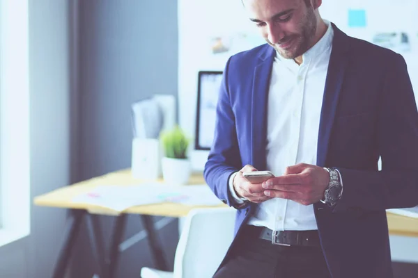 Joven diseñador escribiendo sms en su oficina —  Fotos de Stock