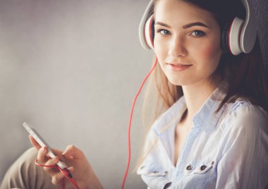 Katta oturan ve müzik dinleme genç mutlu kız
