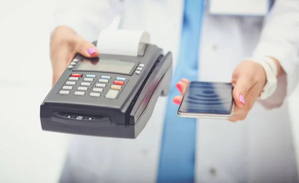 El doctor tiene la terminal de pagos en sus manos. Pagar por atención médica. Doctor. — Foto de Stock