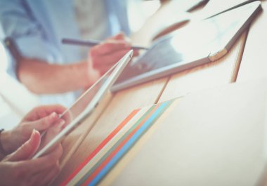 İnternette çalışırken bilgisayarın ve dizüstü bilgisayarın önünde grafik stüdyosunda oturan genç tasarımcının portresi.