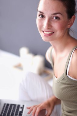 Kupası ve tablet duvarının yakınında katta oturan çekici beyaz kız