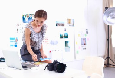 Masanın yanında genç ve güzel bir fotoğrafçının portresi.