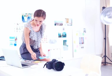 Masanın yanında genç ve güzel bir fotoğrafçının portresi.