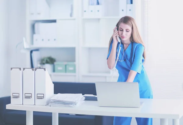 Female doctor talking on phone in diagnostic center — Stock Photo, Image