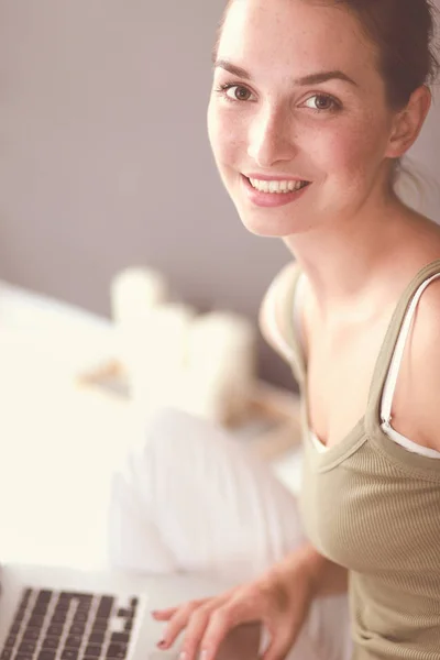 Attraktive kaukasische Mädchen sitzt auf dem Boden mit Tasse und Tablette in der Nähe der Wand — Stockfoto