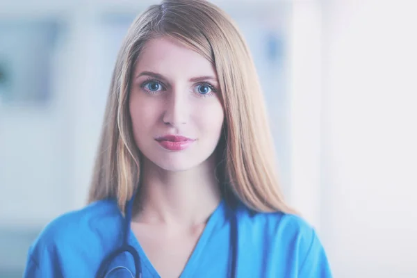 Portret kobiety-lekarza ze stetoskopem w korytarzu szpitalnym, trzymającej folder. — Zdjęcie stockowe