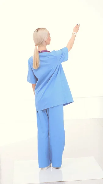 Muotokuva naislääkärin seisoo vastaan eristetty valkoisella pohjalla. Naislääkäri. — kuvapankkivalokuva