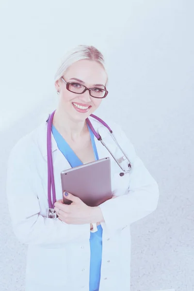 Kobieta lekarz za pomocą tabletki cyfrowej i stojąc na białym tle. Lekarki. — Zdjęcie stockowe