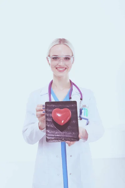 Médica jovem segurando um coração vermelho, isolado em fundo branco. Mulher médica — Fotografia de Stock