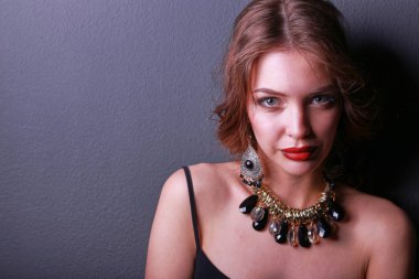 Siyah elbiseli, akşam makyajlı güzel bir kadın.