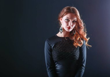 Siyah elbiseli, akşam makyajlı güzel bir kadın.