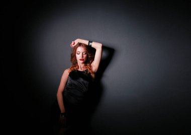 Siyah elbiseli, akşam makyajlı güzel bir kadın.