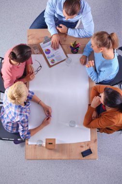 İş adamları toplantıda, ofiste oturup tartışıyorlar.