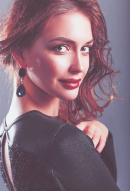 Siyah elbiseli, akşam makyajlı güzel bir kadın.