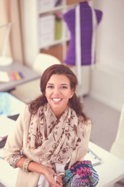 Stüdyoda çalışan genç kadın moda tasarımcısı.