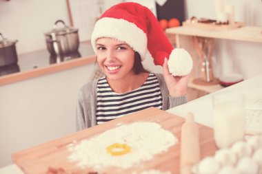Kadın mutfakta Noel kurabiyesi yapıyor.