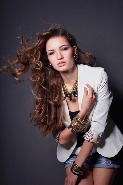 Portrait of a young smiling woman on a gray wall background — Stock Photo, Image