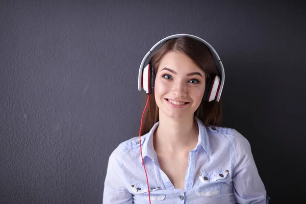 Jovem menina feliz sentado no chão e ouvir música — Fotografia de Stock