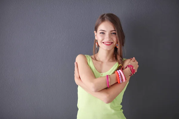 Portret van een jonge glimlachende vrouw op een grijze achtergrond — Stockfoto