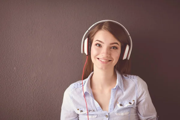 Young happy girl sitting on floor and listening music — Stock Photo, Image