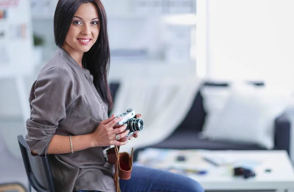 Retrato de una joven sonriente con cámara sentada en un apartamento tipo loft — Foto de Stock