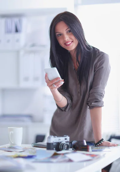 Portrait de jeune femme souriante avec caméra assise dans un appartement loft — Photo