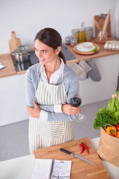 Mooie vrouw die thuis wat wijn drinkt in de keuken — Stockfoto