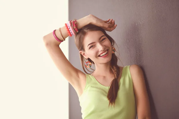 Retrato de una joven sonriente sobre un fondo de pared gris —  Fotos de Stock