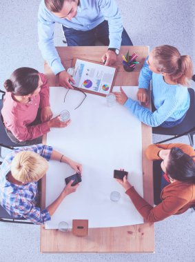 İş adamları toplantıda, ofiste oturup tartışıyorlar.