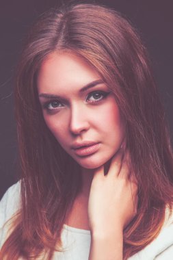 Güzellik. Koyu arka plan üzerinde genç bir kadın portresi