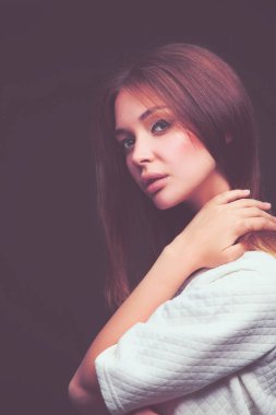 Güzellik. Koyu arka plan üzerinde genç bir kadın portresi