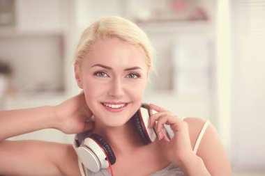 Evdeki genç ve güzel kadın kanepede oturup müzik dinliyor.