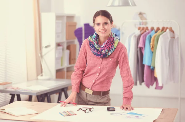 Schöne Modedesignerin sitzt am Schreibtisch im Atelier — Stockfoto