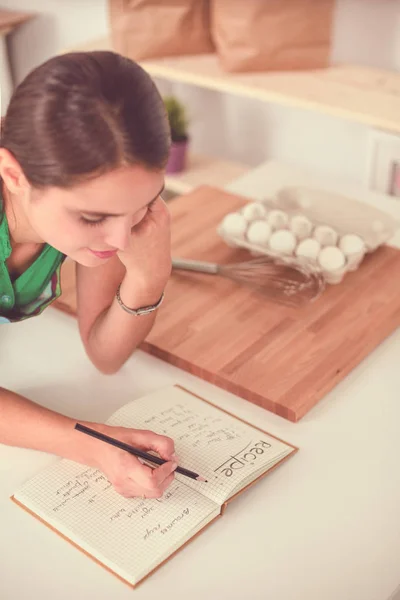 Jonge vrouw schrijft iets in haar notitieblok. — Stockfoto