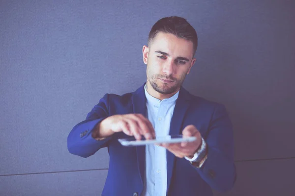 Joven empresario sentado aislado sobre fondo gris. — Foto de Stock