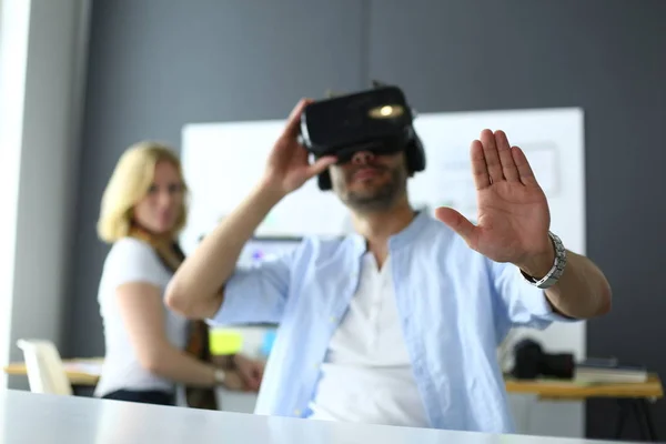 Young male software programmer testing a new app with 3d virtual reality glasses in office.