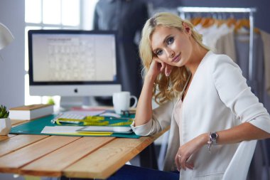 Moda tasarımcısı kadın stüdyoda tasarımları üzerinde çalışıyor..