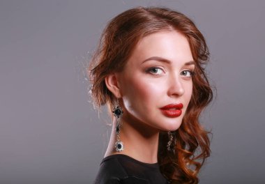 Siyah elbiseli, akşam makyajlı güzel bir kadın.