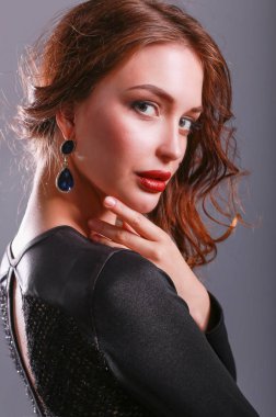 Siyah elbiseli, akşam makyajlı güzel bir kadın.