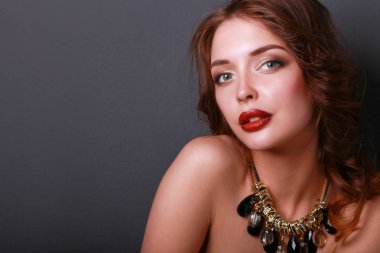 Siyah elbiseli, akşam makyajlı güzel bir kadın.