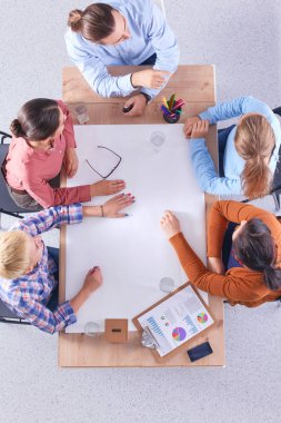 İş adamları toplantıda, ofiste oturup tartışıyorlar.