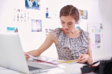 Masanın yanında genç ve güzel bir fotoğrafçının portresi.