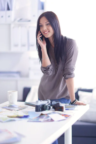 Portrait of smiling young woman with camera sitting in loft apartment — Stock Photo, Image